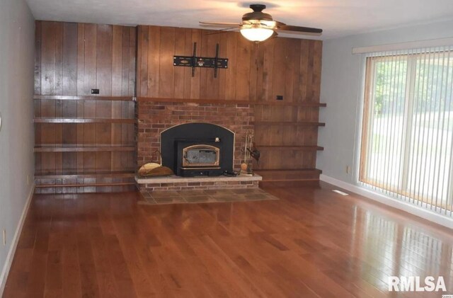 2034 W Wilmar Dr, Quincy, IL 62301 - unfurnished living room featuring a ceiling fan, wood finished floors, baseboards, and wooden walls