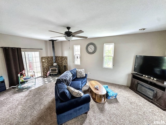 52 Chickasaw St, Mcclure, IL 62957 - carpeted living area with a wood stove, plenty of natural light, a textured ceiling, and ceiling fan