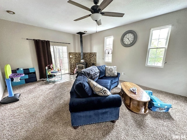 52 Chickasaw St, Mcclure, IL 62957 - carpeted living area with a wood stove, ceiling fan, and plenty of natural light