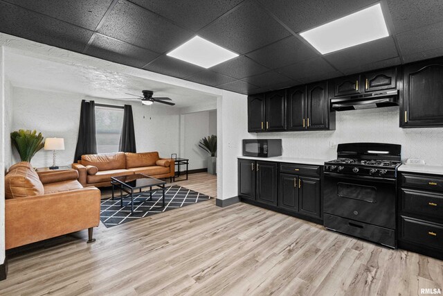 2400 24th St, Rock Island, IL 61201 - kitchen featuring under cabinet range hood, black appliances, dark cabinets, and a drop ceiling