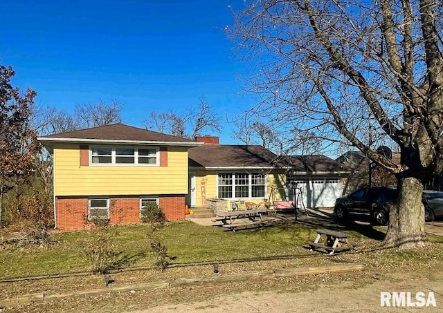 1436 Main Ave, Clinton, IA 52732 - split level home with a garage, a front lawn, brick siding, and a chimney