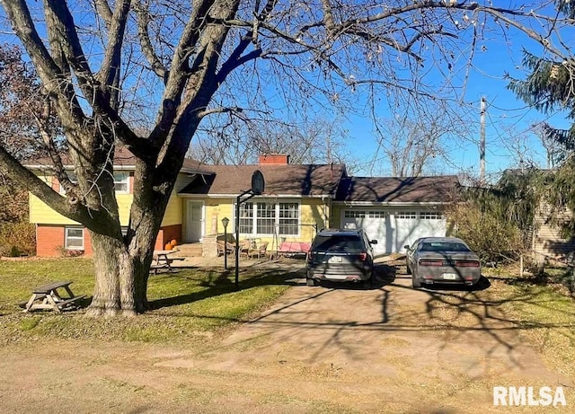 1436 Main Ave, Clinton, IA 52732 - view of front facade featuring driveway, a garage, a chimney, and a front yard