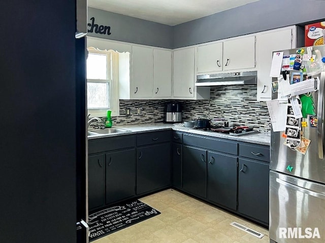 1436 Main Ave, Clinton, IA 52732 - kitchen featuring stainless steel appliances, under cabinet range hood, a sink, decorative backsplash, and light countertops
