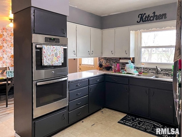 1436 Main Ave, Clinton, IA 52732 - kitchen featuring stainless steel double oven, white cabinets, light floors, and light countertops
