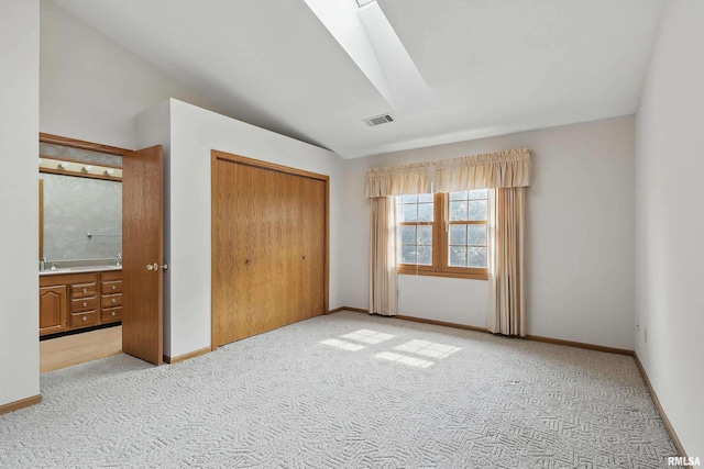4612 Marquette St, Davenport, IA 52806 - unfurnished bedroom with light carpet, a closet, vaulted ceiling, baseboards, and connected bathroom