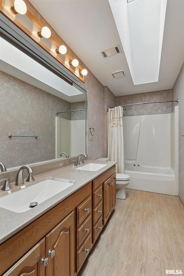 4612 Marquette St, Davenport, IA 52806 - full bath with wood finished floors, toilet, shower / tub combo, and double vanity