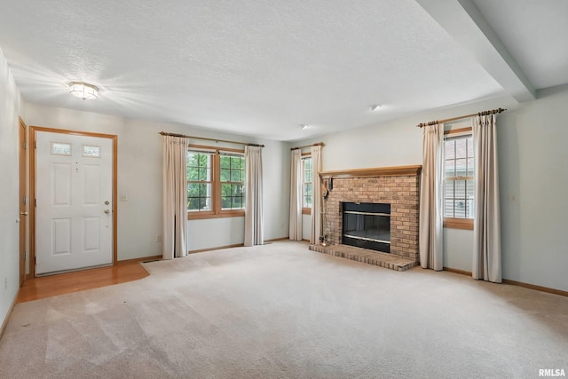 4612 Marquette St, Davenport, IA 52806 - unfurnished living room featuring carpet, baseboards, a textured ceiling, and a fireplace