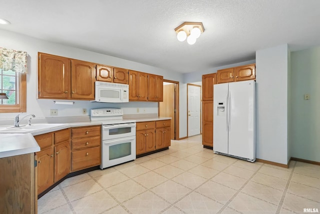 4612 Marquette St, Davenport, IA 52806 - kitchen with white appliances, a sink, light countertops, brown cabinetry, and a textured ceiling