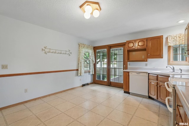 4612 Marquette St, Davenport, IA 52806 - kitchen with white appliances, a sink, light countertops, a textured ceiling, and brown cabinets