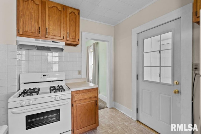 546 21st Ave, Moline, IL 61265 - kitchen featuring white range with gas cooktop, under cabinet range hood, light countertops, ornamental molding, and brown cabinetry