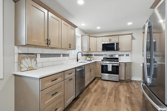 3610 Tam-O-Shanter Dr, Bettendorf, IA 52722 - kitchen featuring appliances with stainless steel finishes, a sink, backsplash, dark wood-style floors, and recessed lighting