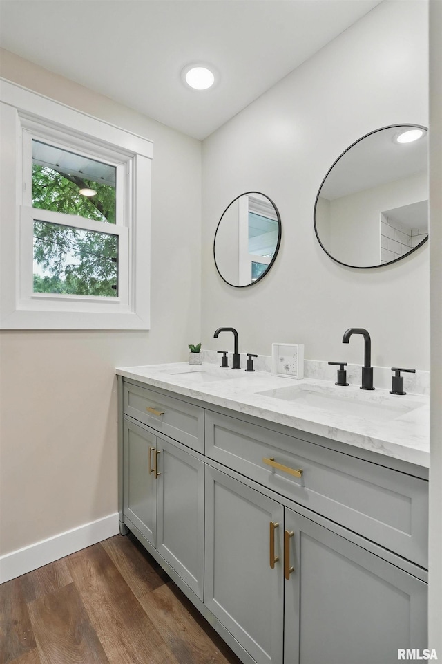 3610 Tam-O-Shanter Dr, Bettendorf, IA 52722 - bathroom featuring double vanity, wood finished floors, and baseboards