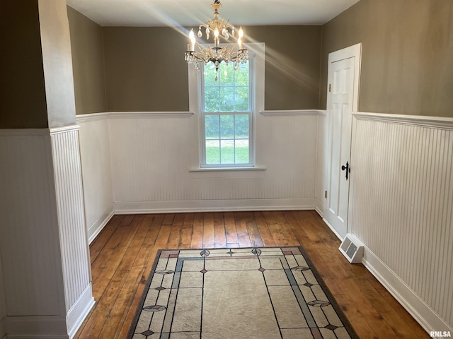 706 N Main St, Port Byron, IL 61275 - unfurnished dining area with hardwood / wood-style floors, a wainscoted wall, and a chandelier
