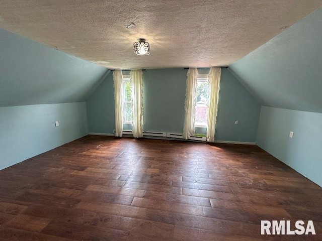317 9th St, De Witt, IA 52742 - bonus room featuring dark wood-type flooring, vaulted ceiling, a textured ceiling, and a baseboard radiator