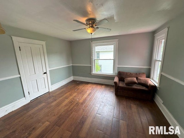 317 9th St, De Witt, IA 52742 - living area with dark wood-style flooring, ceiling fan, and baseboards