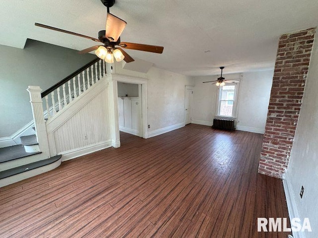 317 9th St, De Witt, IA 52742 - unfurnished living room with radiator, ceiling fan, wood finished floors, stairs, and baseboards