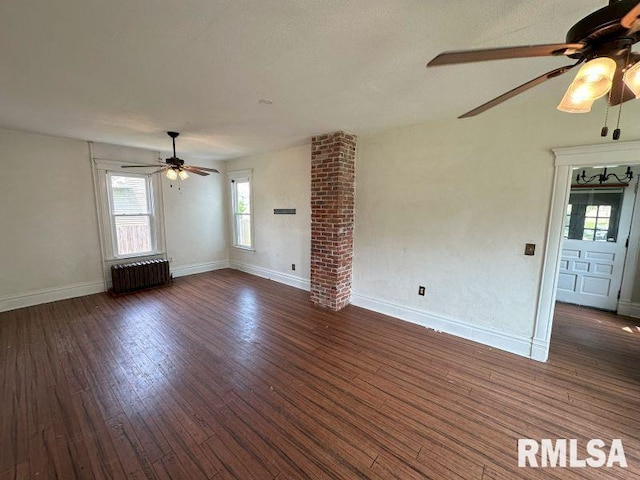 317 9th St, De Witt, IA 52742 - unfurnished living room with radiator, ceiling fan, wood finished floors, and baseboards