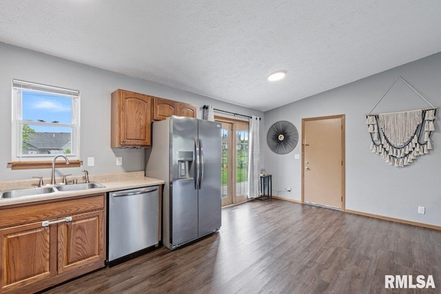 3115 W 63rd St, Davenport, IA 52806 - kitchen featuring appliances with stainless steel finishes, a sink, dark wood finished floors, a textured ceiling, and brown cabinetry