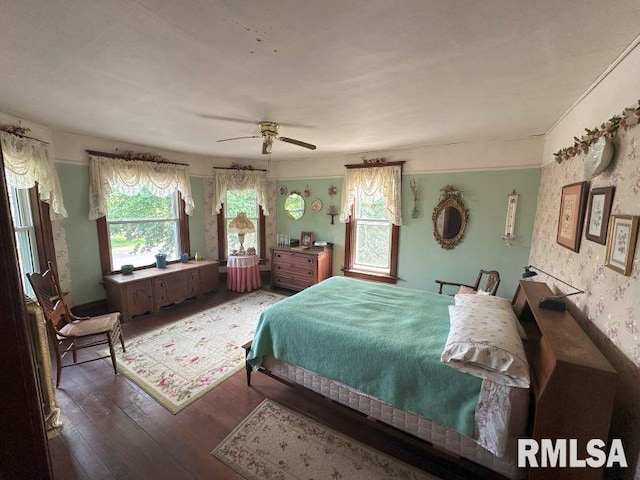 605 Fulton St, Grand Mound, IA 52751 - bedroom featuring multiple windows, wood finished floors, wallpapered walls, and a ceiling fan