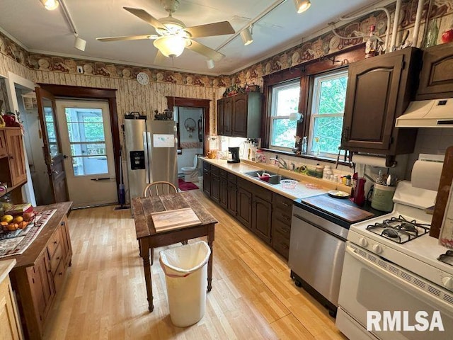 605 Fulton St, Grand Mound, IA 52751 - kitchen featuring appliances with stainless steel finishes, wallpapered walls, a sink, rail lighting, and custom exhaust hood