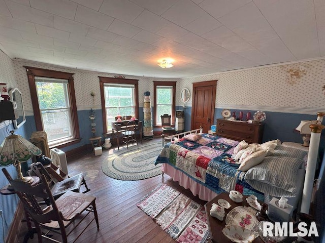 605 Fulton St, Grand Mound, IA 52751 - bedroom with wallpapered walls, hardwood / wood-style floors, and baseboards