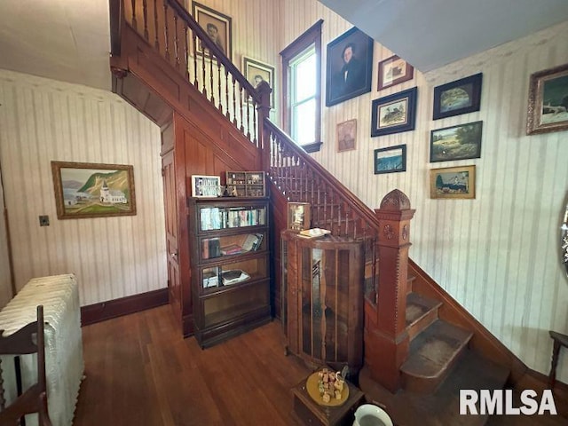 605 Fulton St, Grand Mound, IA 52751 - stairway featuring radiator, wood finished floors, wood walls, and baseboards