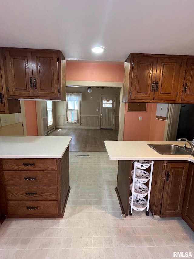 246 Willard St, Kewanee, IL 61443 - kitchen featuring a sink, light countertops, a wainscoted wall, a peninsula, and open floor plan