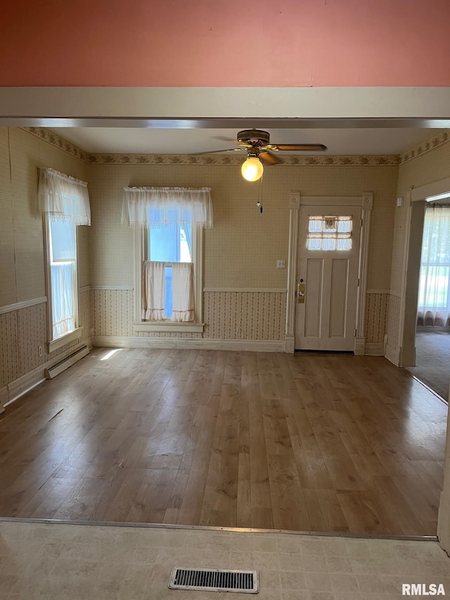 246 Willard St, Kewanee, IL 61443 - entryway with wallpapered walls, wood-type flooring, a baseboard radiator, baseboards, and healthy amount of natural light