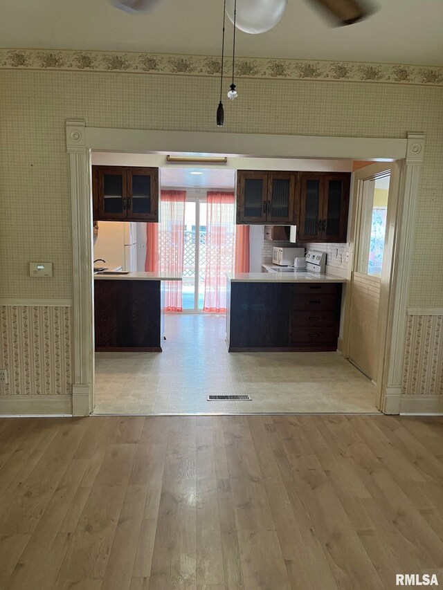 246 Willard St, Kewanee, IL 61443 - kitchen with wallpapered walls, light wood-style floors, healthy amount of natural light, and baseboards