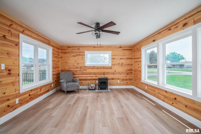 4418 11th St, East Moline, IL 61244 - unfurnished room with baseboards, light wood-type flooring, healthy amount of natural light, a ceiling fan, and wooden walls