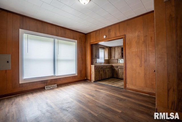 710 S Bentley St, Marion, IL 62959 - unfurnished dining area featuring wooden walls, wood finished floors, a sink, electric panel, and baseboards