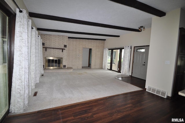 18616 N 35th Ave, East Moline, IL 61244 - unfurnished living room with beamed ceiling, wood finished floors, brick wall, and a fireplace