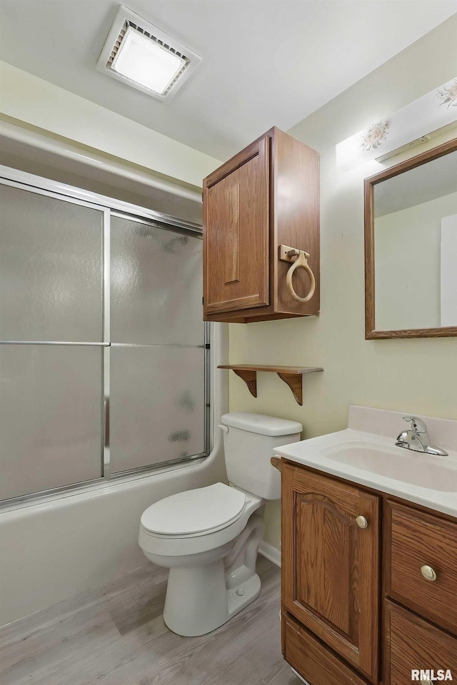 2947 12th Ave, Moline, IL 61265 - bathroom featuring vanity, wood finished floors, toilet, and combined bath / shower with glass door