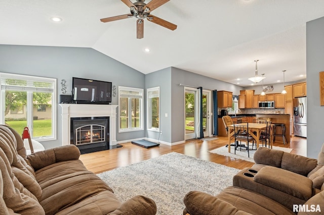 308 N 9th Ave N, Fulton, IL 61252 - living area with lofted ceiling, ceiling fan, recessed lighting, light wood-type flooring, and a warm lit fireplace