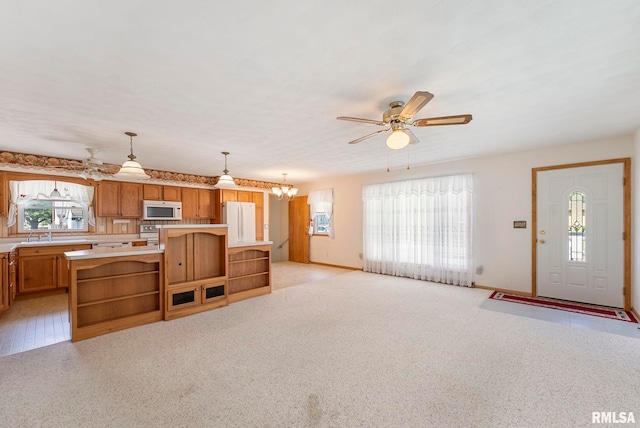 605 SW 5th Ave, Aledo, IL 61231 - kitchen featuring white appliances, light countertops, a kitchen island, a ceiling fan, and brown cabinets