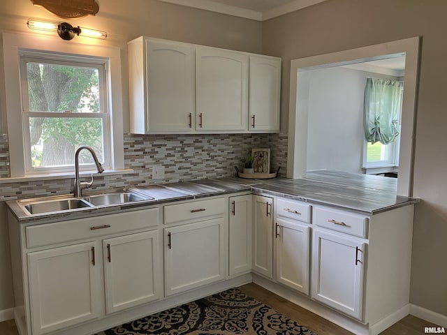 136 W Mill St, Kewanee, IL 61443 - kitchen with a sink, white cabinets, backsplash, light countertops, and plenty of natural light
