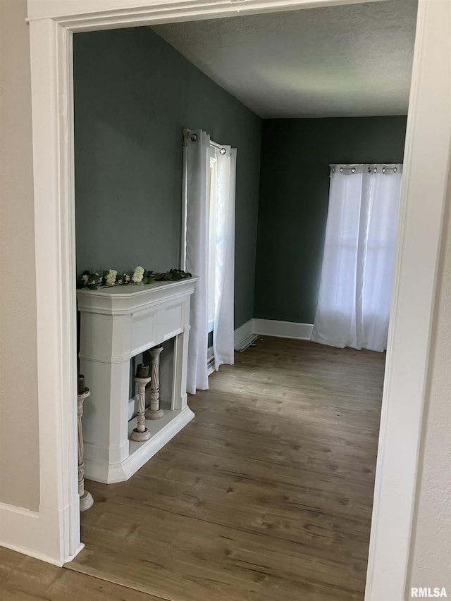 136 W Mill St, Kewanee, IL 61443 - unfurnished living room featuring baseboards, wood finished floors, and a textured ceiling