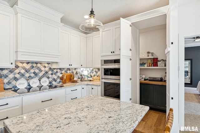 18101 271st St, Long Grove, IA 52756 - kitchen with stainless steel double oven, black electric stovetop, white cabinetry, wood finished floors, and decorative backsplash