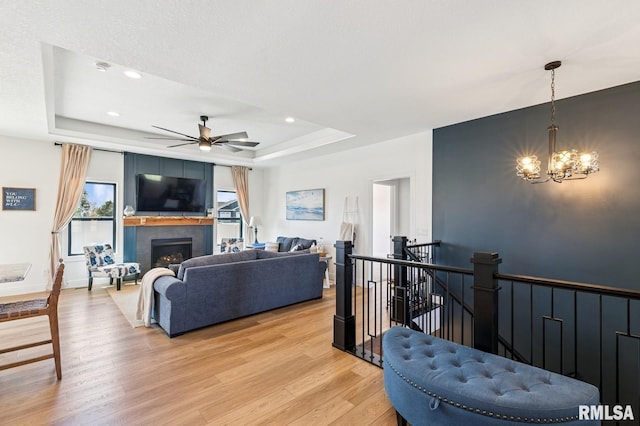 18101 271st St, Long Grove, IA 52756 - living room with a raised ceiling, light wood-type flooring, ceiling fan, a chandelier, and a tile fireplace