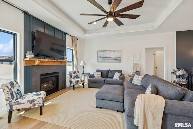 18101 271st St, Long Grove, IA 52756 - living area with wood finished floors, a ceiling fan, a tile fireplace, and a tray ceiling