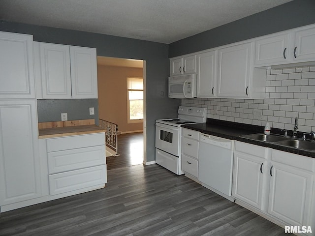 4125 Cresthill Dr, Davenport, IA 52806 - kitchen featuring white appliances, backsplash, white cabinetry, dark wood-style floors, and dark countertops