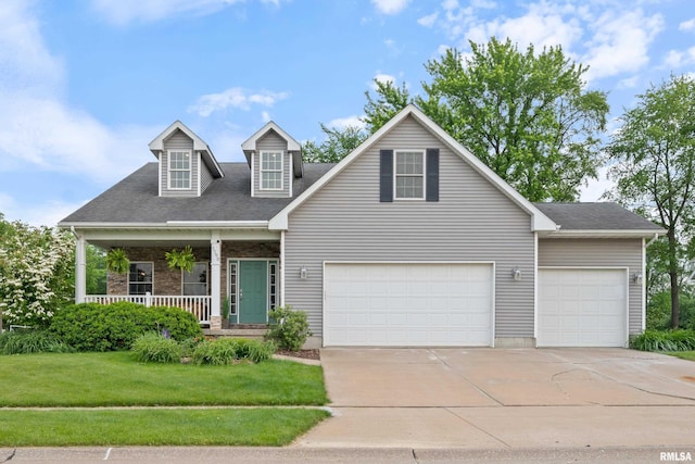 1100 Wild W Dr, Le Claire, IA 52753 - view of front of property with concrete driveway, a front yard, covered porch, a garage, and a shingled roof