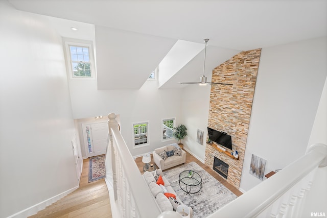 1100 Wild W Dr, Le Claire, IA 52753 - living room featuring light wood-style floors, high vaulted ceiling, a fireplace, and ceiling fan