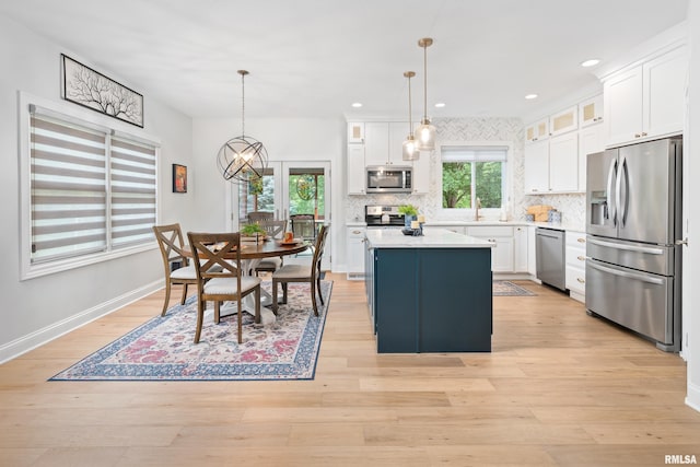 1100 Wild W Dr, Le Claire, IA 52753 - kitchen featuring stainless steel appliances, a center island, light countertops, tasteful backsplash, and recessed lighting