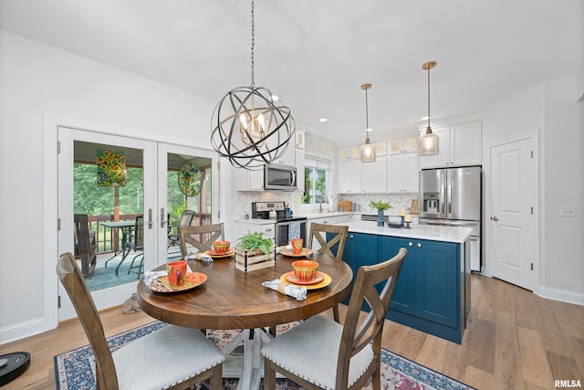 1100 Wild W Dr, Le Claire, IA 52753 - dining area featuring light wood-style flooring, french doors, a chandelier, and recessed lighting