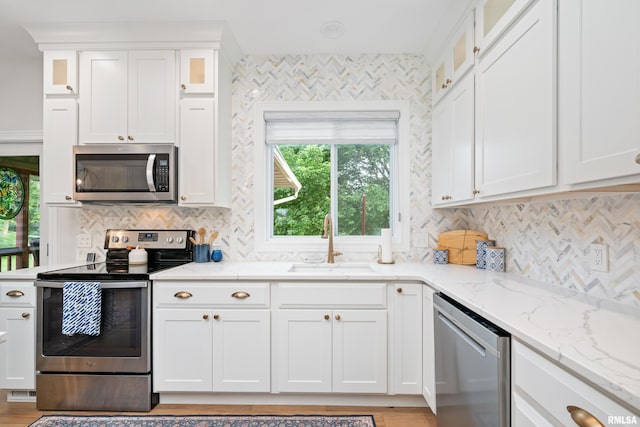 1100 Wild W Dr, Le Claire, IA 52753 - kitchen with stainless steel appliances, tasteful backsplash, white cabinetry, and light stone countertops
