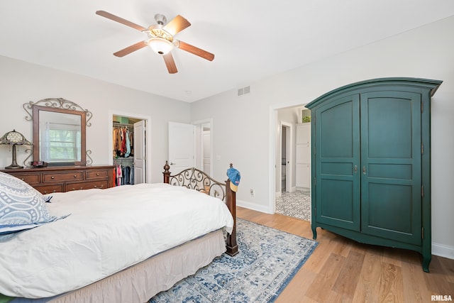 1100 Wild W Dr, Le Claire, IA 52753 - bedroom featuring light wood-type flooring, a walk in closet, a closet, and a ceiling fan