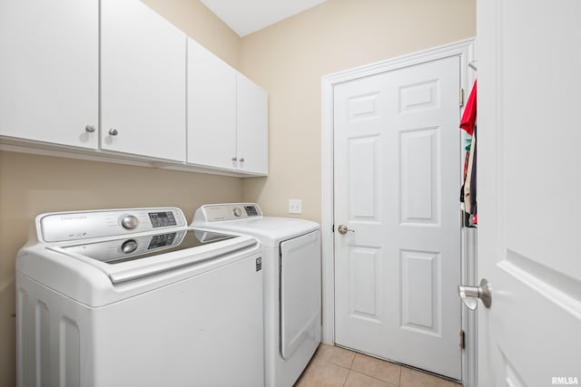 1100 Wild W Dr, Le Claire, IA 52753 - washroom featuring separate washer and dryer, cabinet space, and light tile patterned flooring