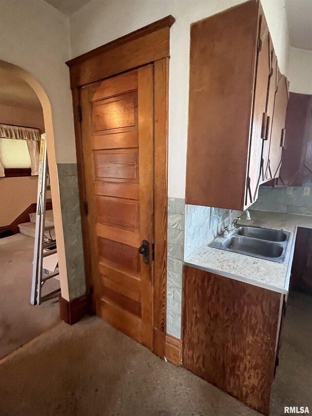 1109 S Michigan St, Davenport, IA 52802 - kitchen featuring a sink, carpet floors, light countertops, and arched walkways