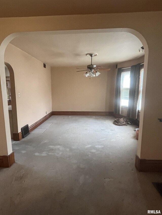 1109 S Michigan St, Davenport, IA 52802 - carpeted spare room featuring a ceiling fan, arched walkways, and baseboards